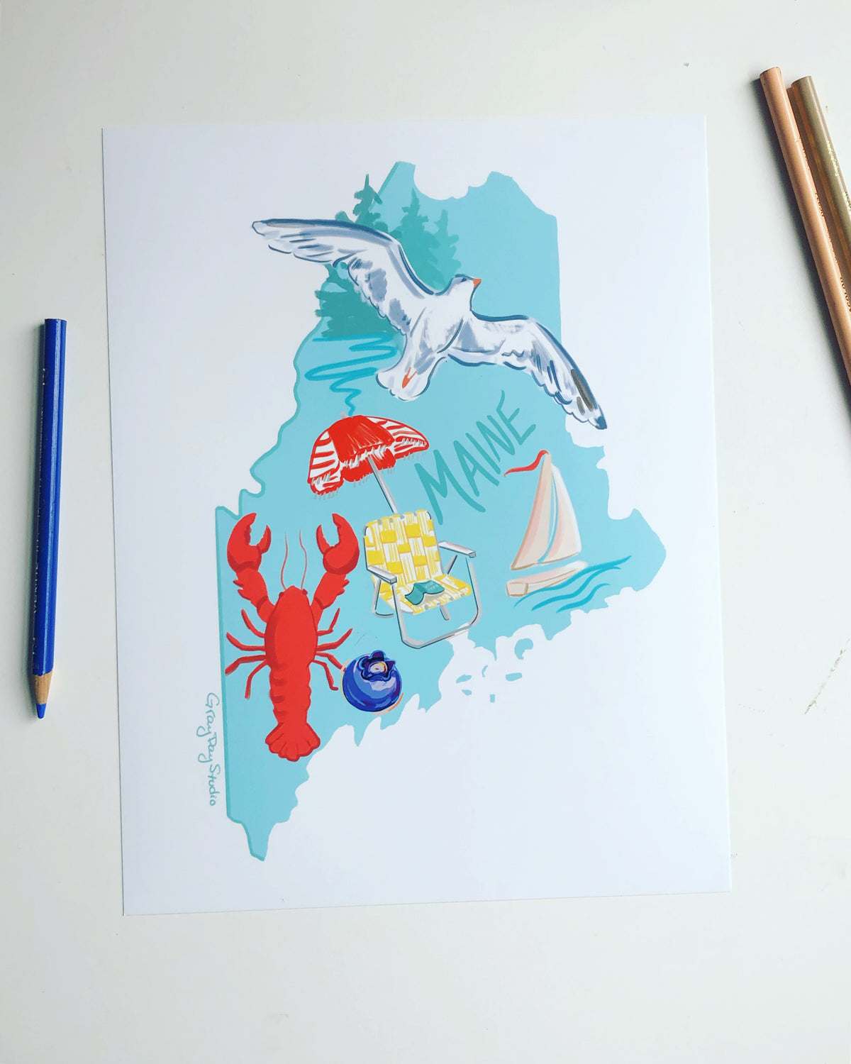 State of Maine artowrk featuring a seagull, sailboat, lobster, blueberry, beach chair and umbrella.